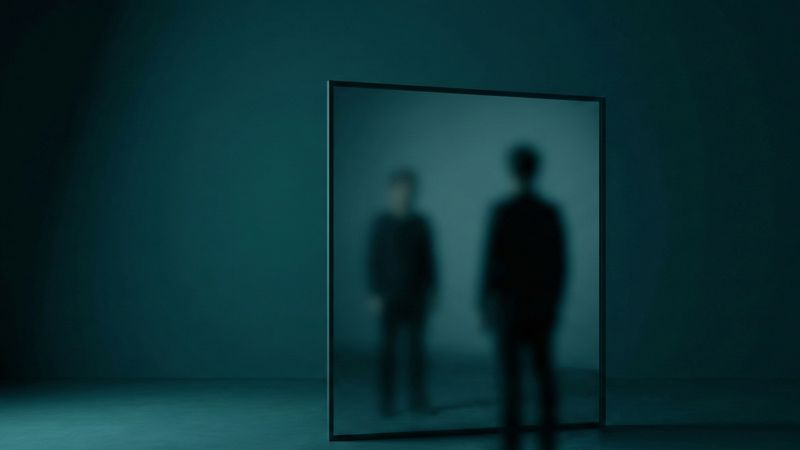 Lustro odbijające rozmytą sylwetkę człowieka, metafora nieświadomości i samopostrzegania